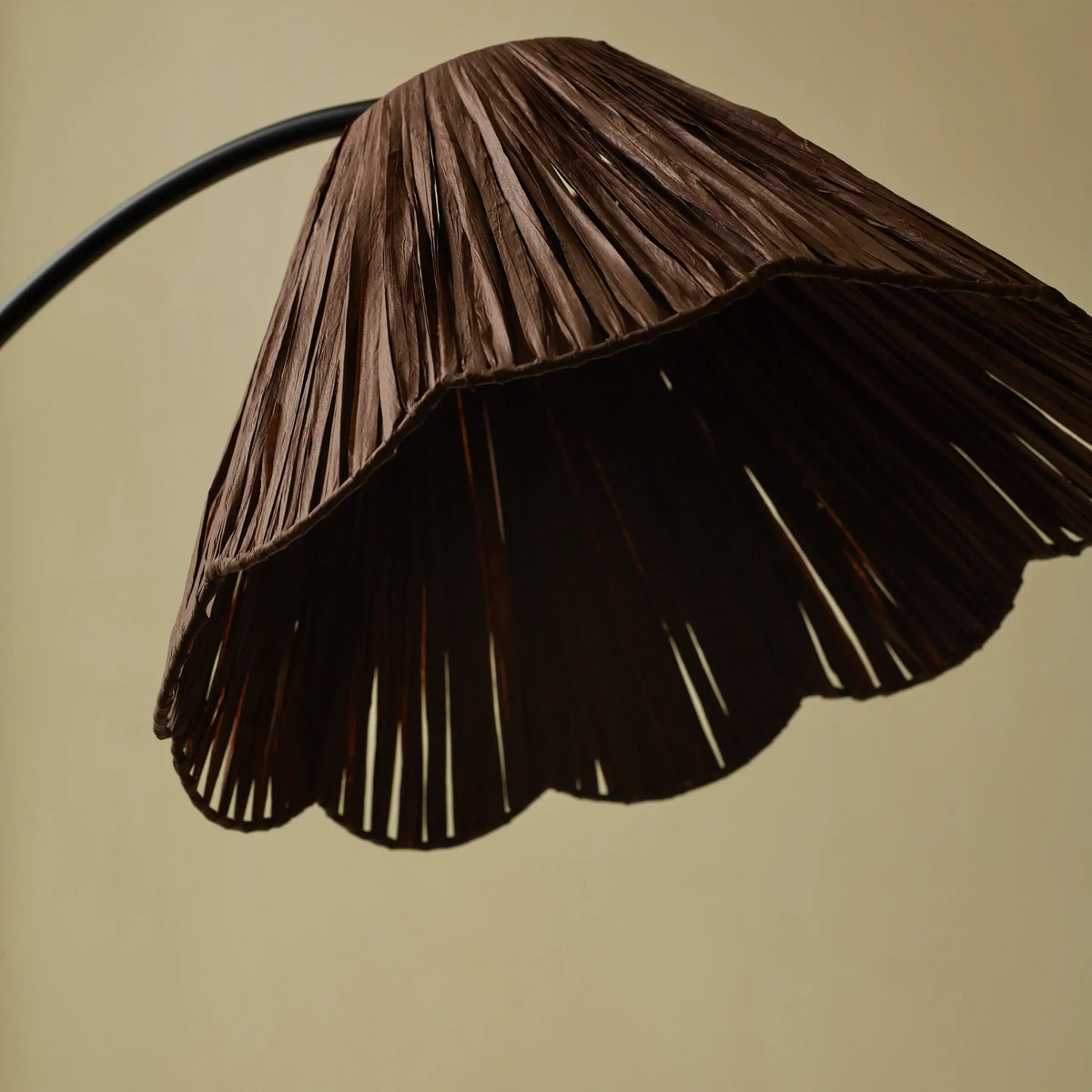Scalloped raffia floor lamp glowing in a cozy living room setting - PABOOM