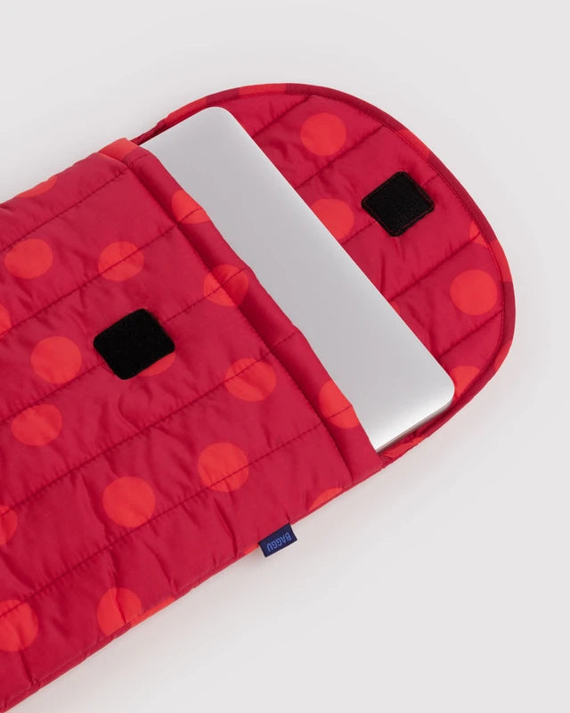 BAGGU Puffy Laptop Sleeve in red polka dot shown holding a laptop for scale