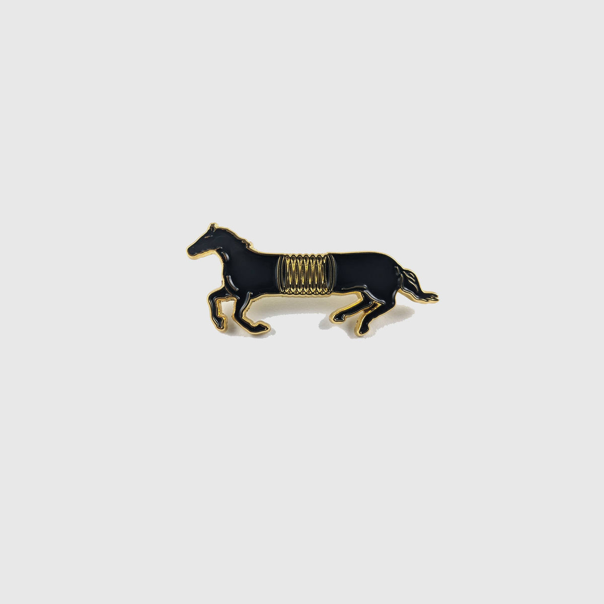 Black and gold enamel pin of a horse mid-gallop with a spring coiled around its middle - PABOOM