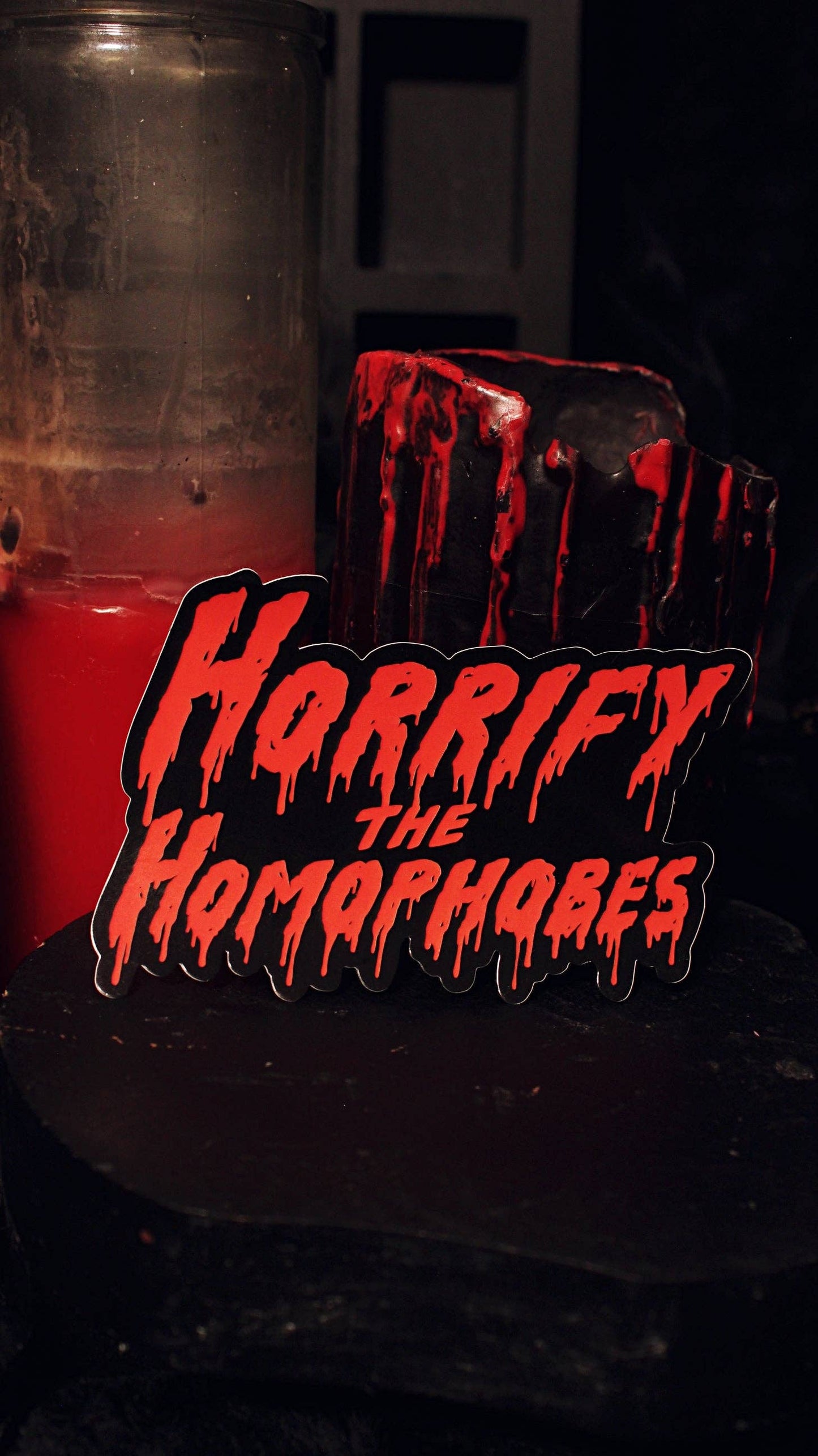 Horrify The Homophobes sticker shown at an angle showing its glossy vinyl finish