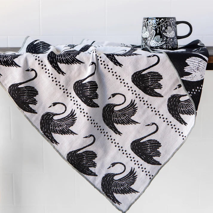 Swan Song dishtowel folded and styled on a kitchen counter – PABOOM