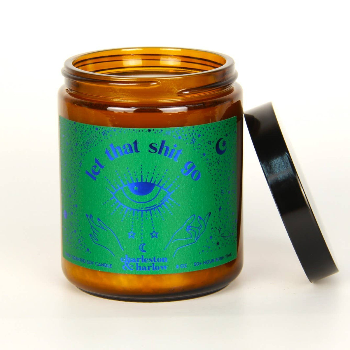 Charleston & Harlow Let That Shit Go soy candle in amber glass jar with green label featuring a blue foil mystic eye illustration