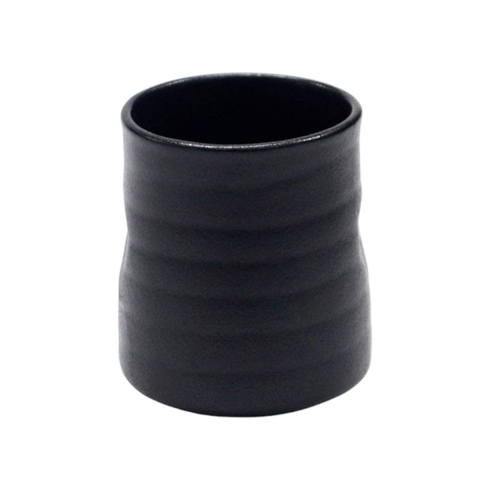 Matte black ceramic yunomi tea cup with a ribbed, hand-thrown texture and a slightly tapered silhouette