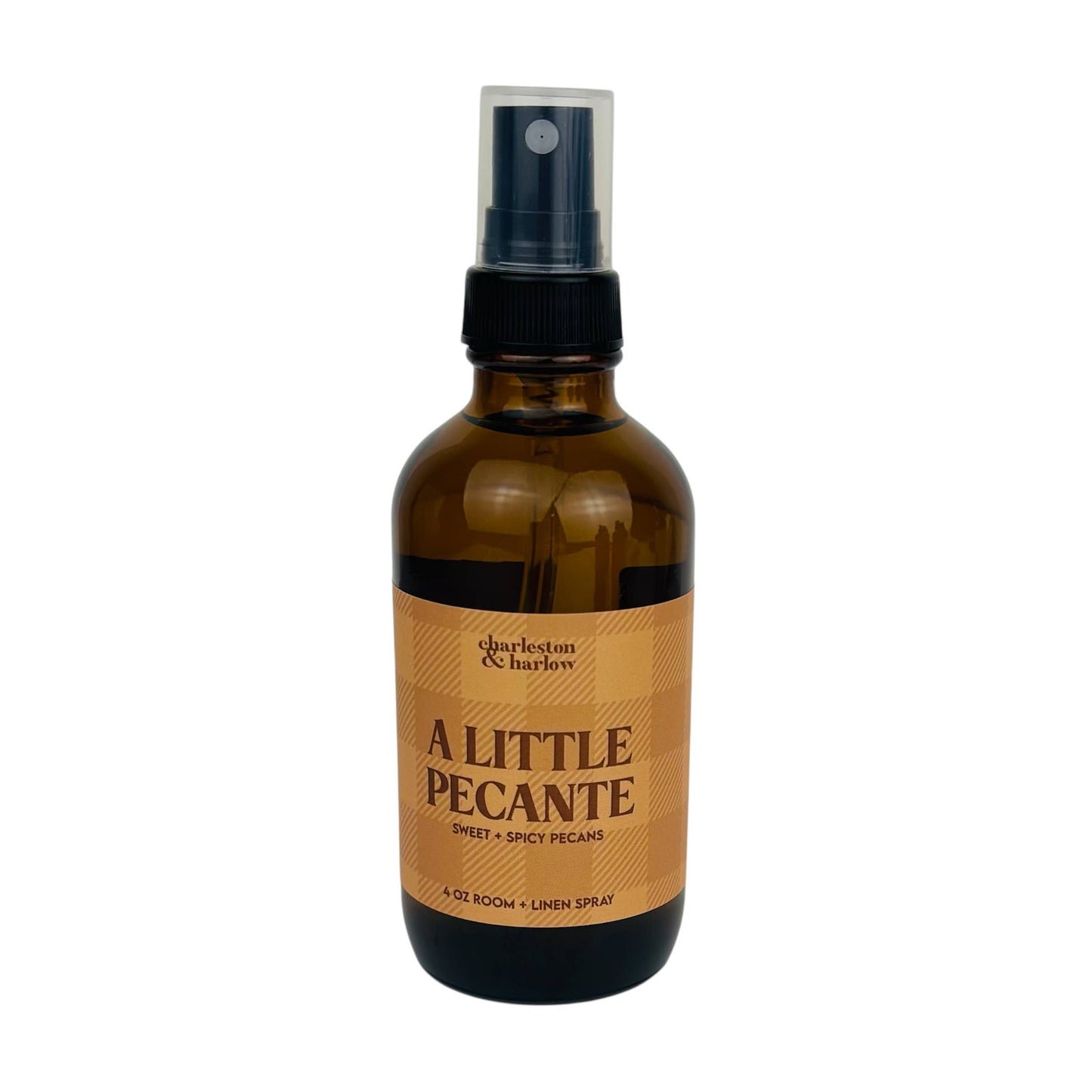 Amber glass spray bottle of Charleston & Harlow A Little Pecanté room and linen spray with tan plaid label