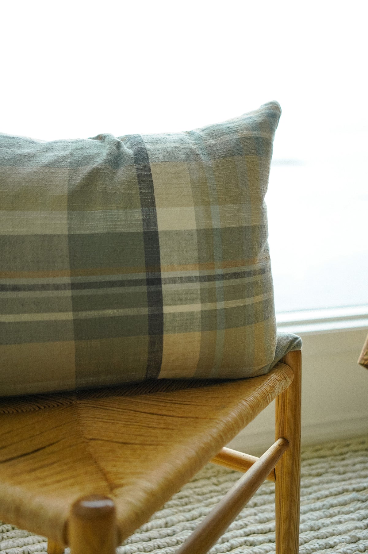 Close-up of the woven plaid pattern on the Delacourt Pillow