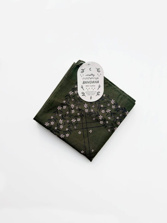 Folded dark olive green cotton bandana with a small repeating floral pattern and a Molly Illustration branded packaging tag