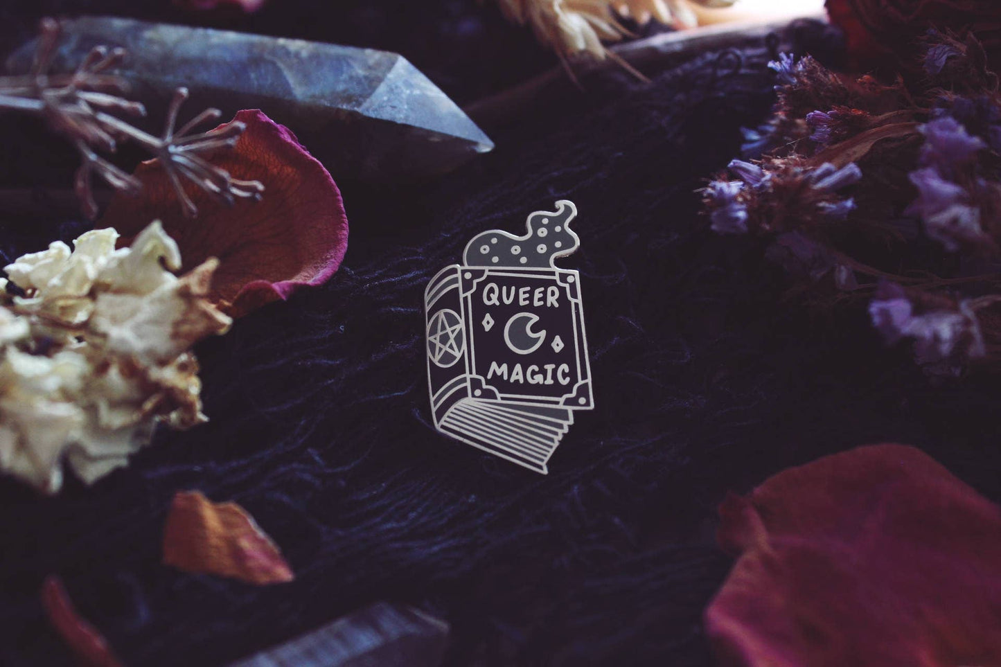 Back view of the Queer Magic pin showing the pin post and rubber back