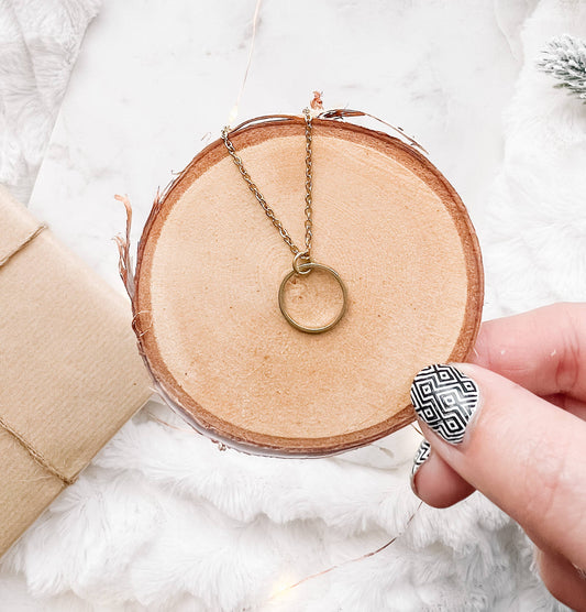 Close-up of raw brass circle pendant necklace chain detail
