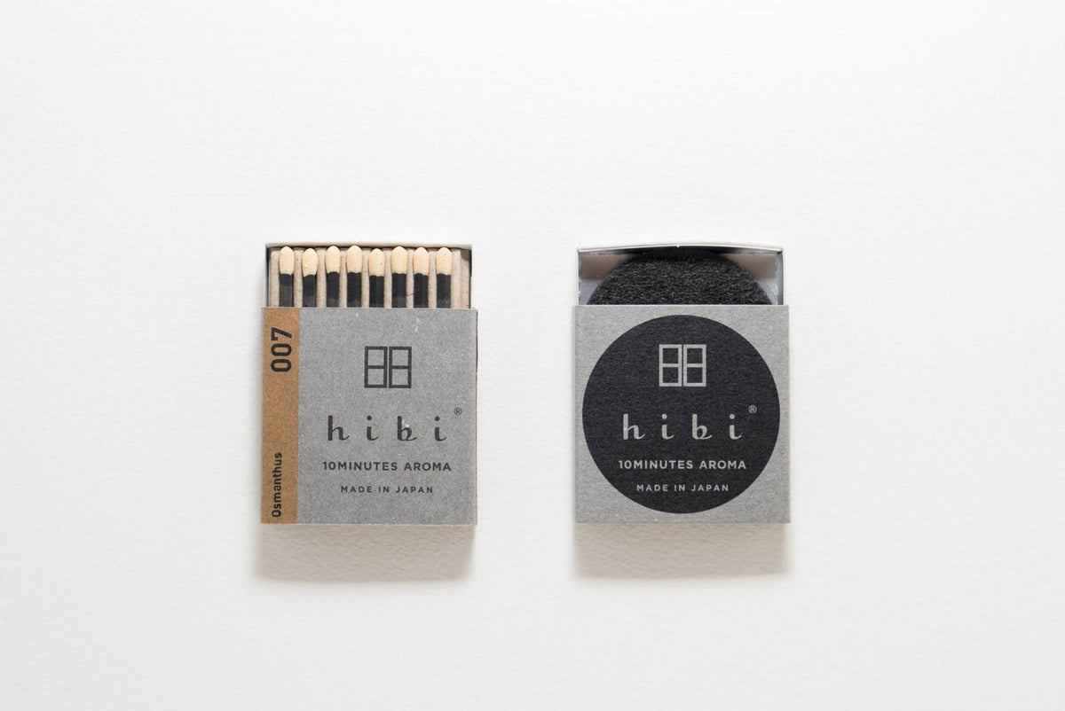 Hibi Osmanthus incense matches in a grey box with orange accent, open to show matchsticks beside a closed box - PABOOM