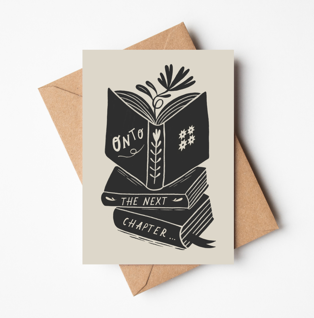 'Onto The Next Chapter...' card featuring a bold black illustration of an open book atop a stack of books, with botanical details, on a cream background