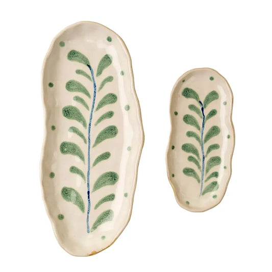 Two ceramic trays with leaf patterns on a beige background