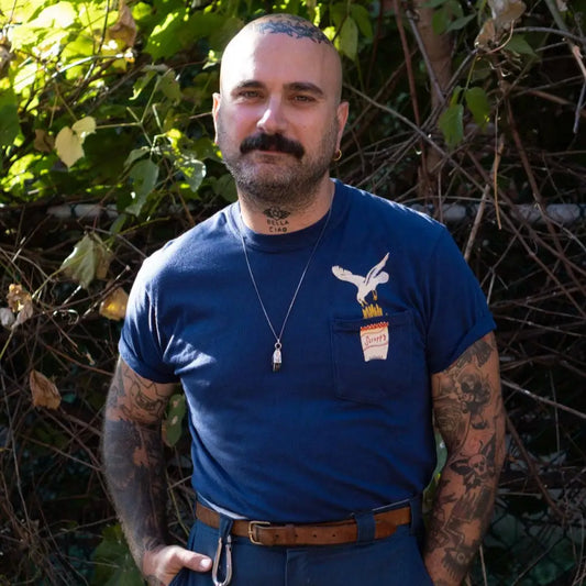 Person wearing T-shirt wth breast pocket a graphic of a seagull eating French fries, cotton, navy blue. - PABOOM