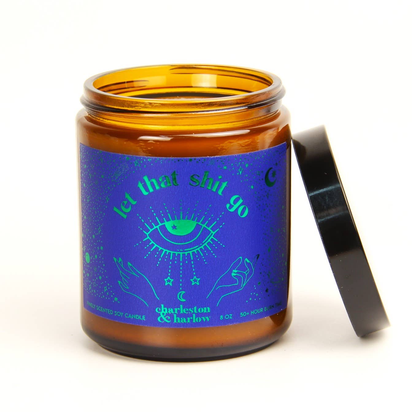 Charleston & Harlow Let That Shit Go soy candle in amber glass jar with blue label featuring a green foil mystic eye illustration