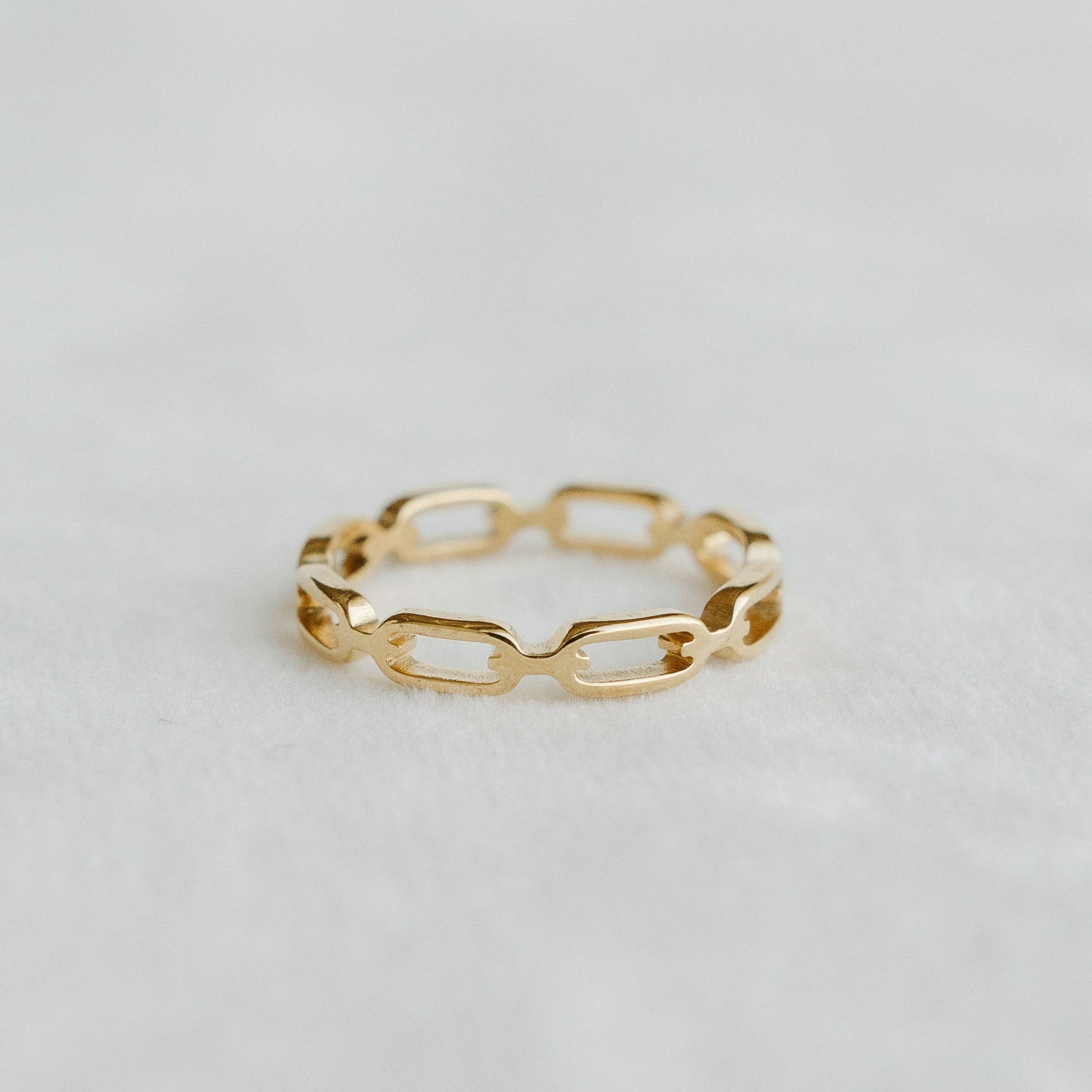 Rosie Band gold interlocking chain-link bracelet on a light textured surface - PABOOM