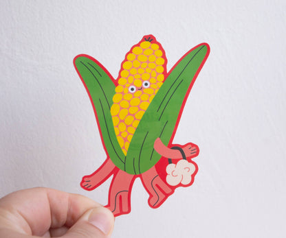 Corn Vinyl Sticker — illustration of a corn character with arms and legs holding a bag of popcorn