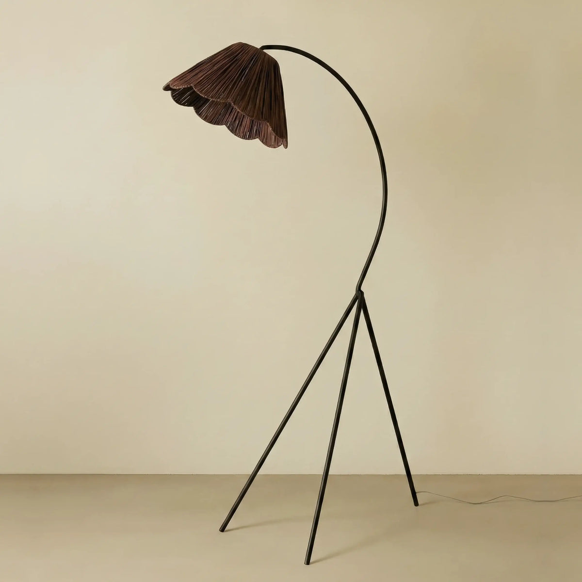Swedish floor lamp with a scalloped brown raffia shade on an arched black tripod stand - PABOOM