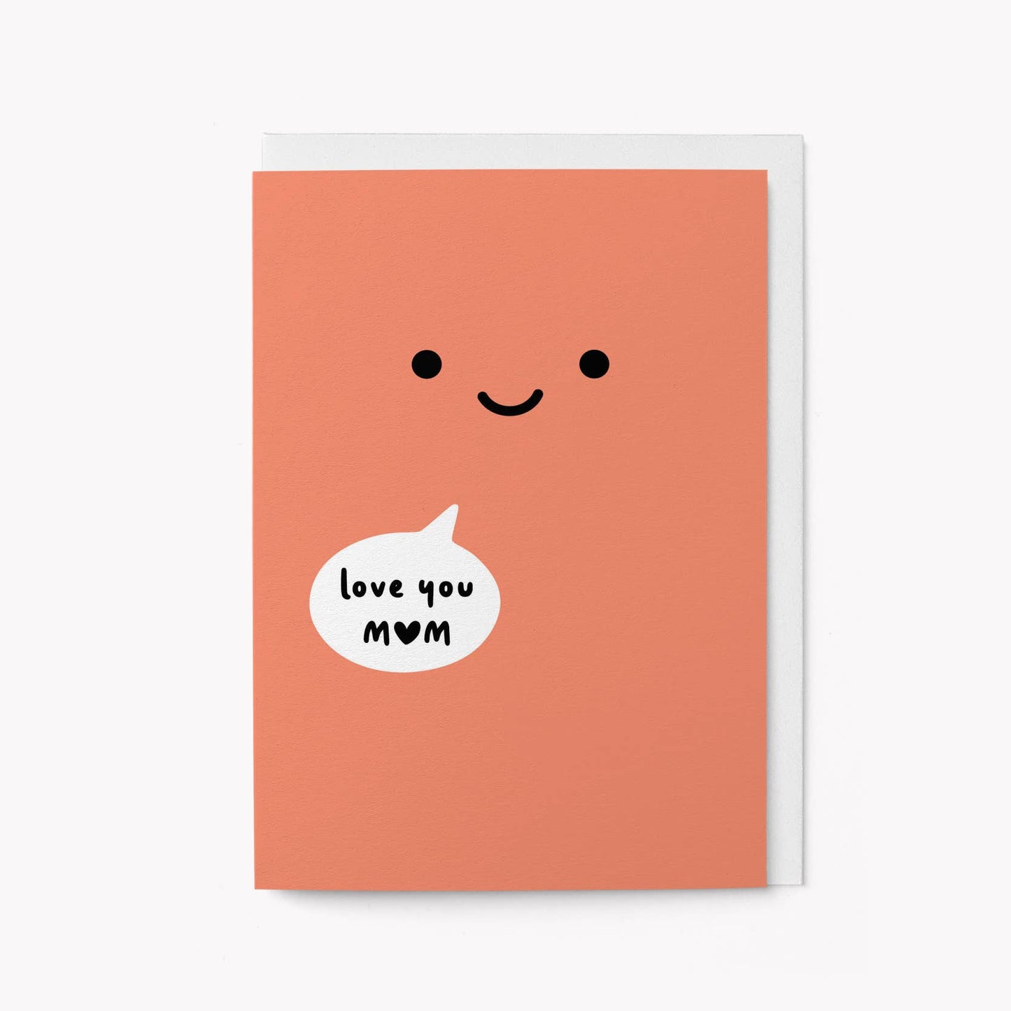 Coral greeting card with a large smiley face and a speech bubble reading 'love you MOM' with a heart in place of the O