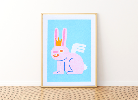 Mini Bunny Risograph Print — illustration of a pink bunny wearing a crown and wings, shown framed against a blue background