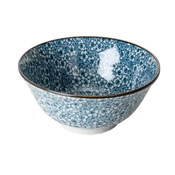 Blue and white porcelain bowl covered in a dense komon-style floral print, viewed from a slight angle