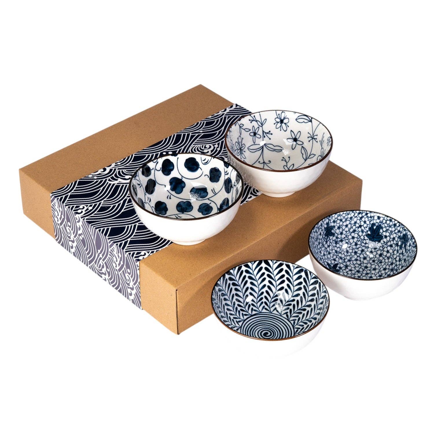 Four indigo and white porcelain rice bowls with mixed floral and geometric patterns resting on their kraft gift box with a wave-print sleeve