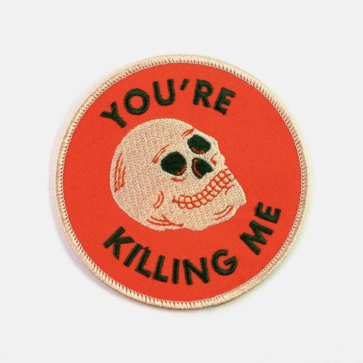 Round red iron-on patch embroidered with a skull and the words You're Killing Me - PABOOM
