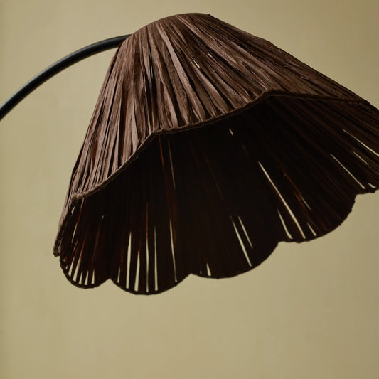 Scalloped raffia floor lamp glowing in a cozy living room setting - PABOOM