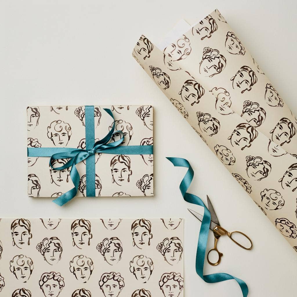 Wrapping paper printed with brown line-art face illustrations on a cream background, tied with teal ribbon