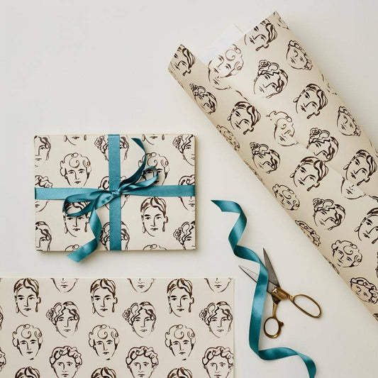 Wrapping paper printed with brown line-art face illustrations on a cream background, tied with teal ribbon