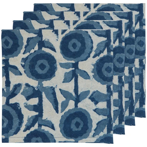 Four folded cotton napkins hand block-printed with a bold navy floral pattern on cream - PABOOM