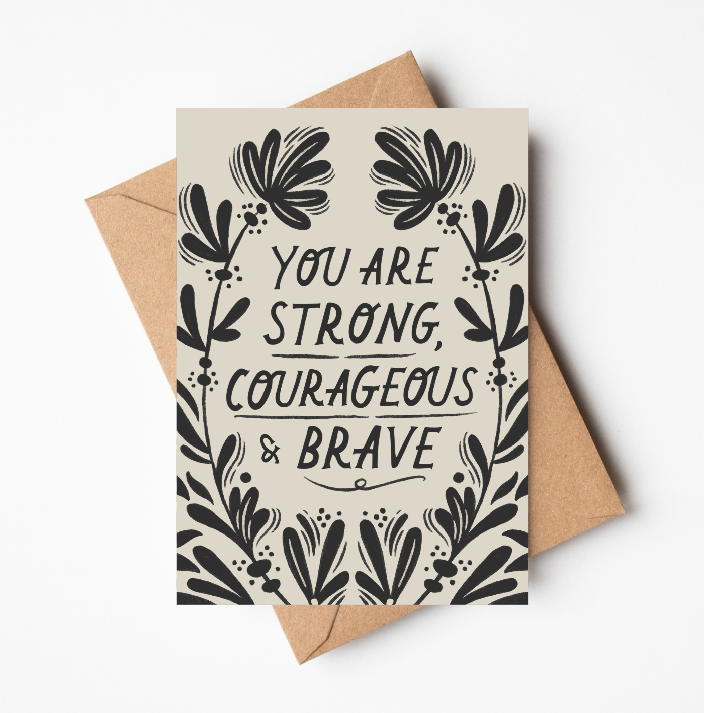 'Strong, Courageous & Brave' card featuring bold black floral border illustration and hand-lettered text reading 'You Are Strong, Courageous & Brave' on a cream background