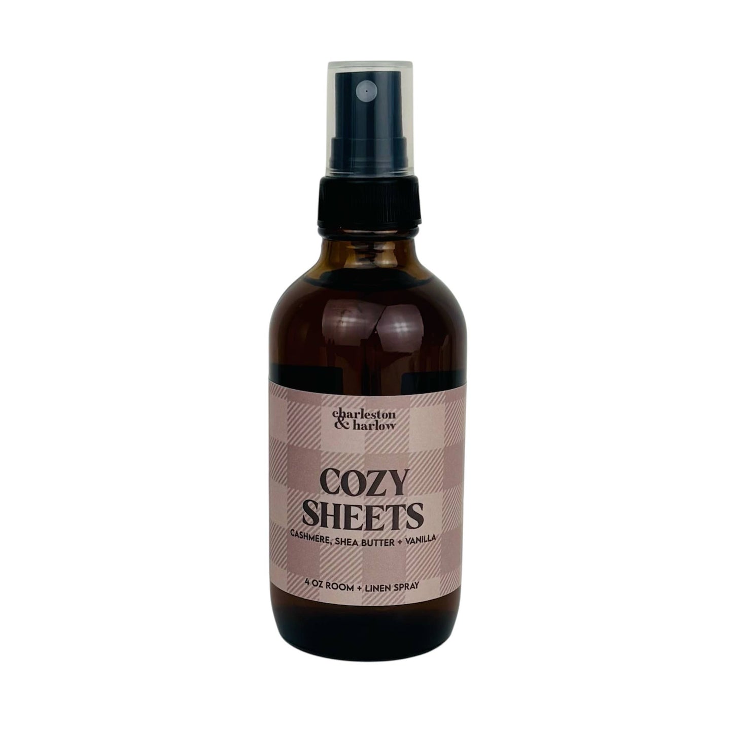 Amber glass spray bottle of Charleston & Harlow Cozy Sheets room and linen spray with tan buffalo check label