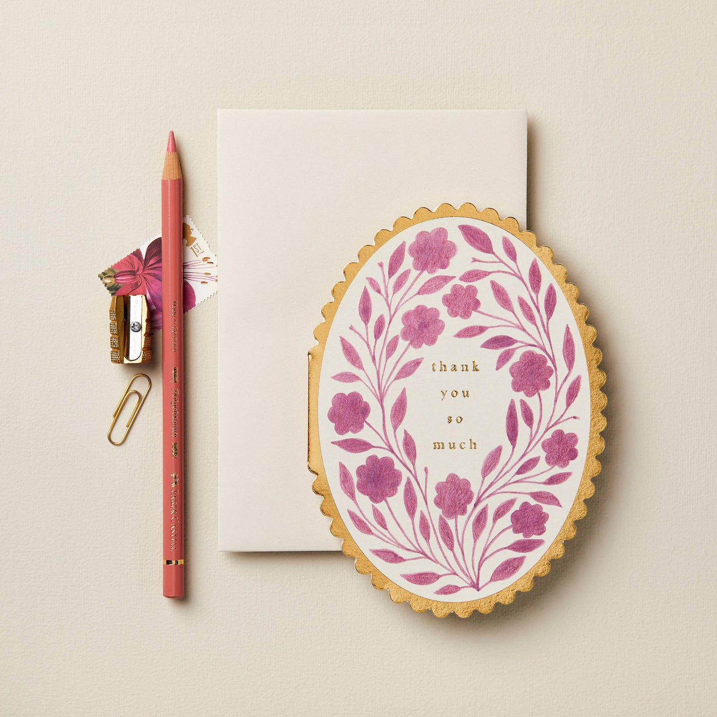 Magenta violet floral wreath on cream oval card with gold scalloped edge, reading Thank You So Much