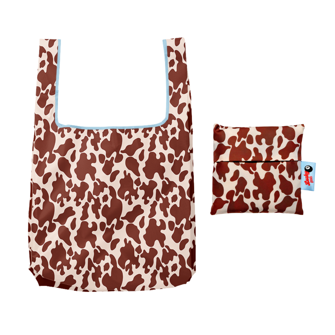 Brown and cream cow-print foldable nylon tote with light blue trim, shown open beside its matching zippered pouch - PABOOM