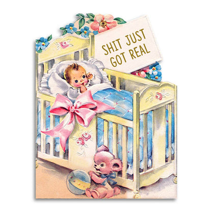 Die-cut vintage illustration of a sleeping baby in a crib with a teddy bear, reading Shit Just Got Real