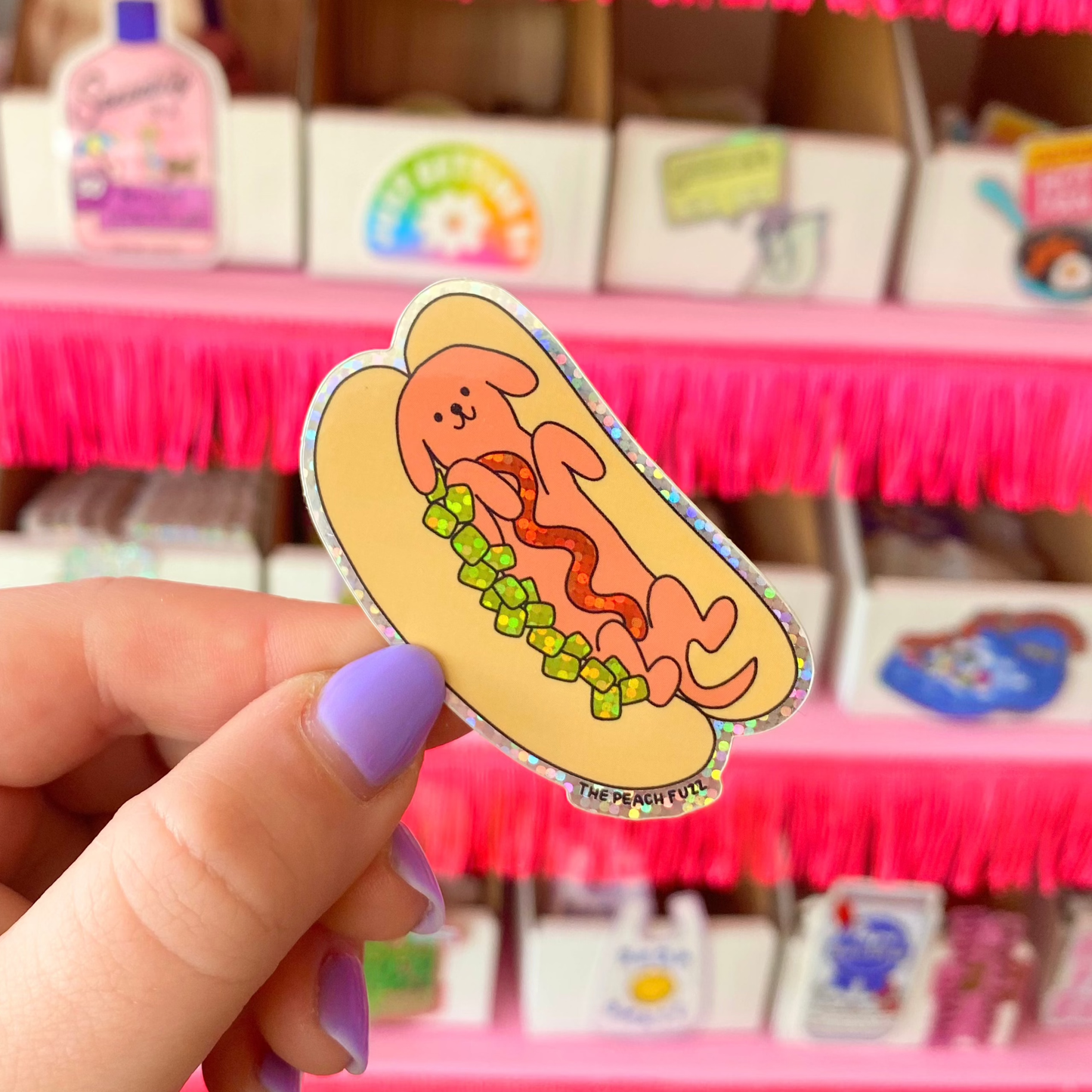 Dog character lying inside a hot dog bun with glittery relish and a ketchup squiggle illustration