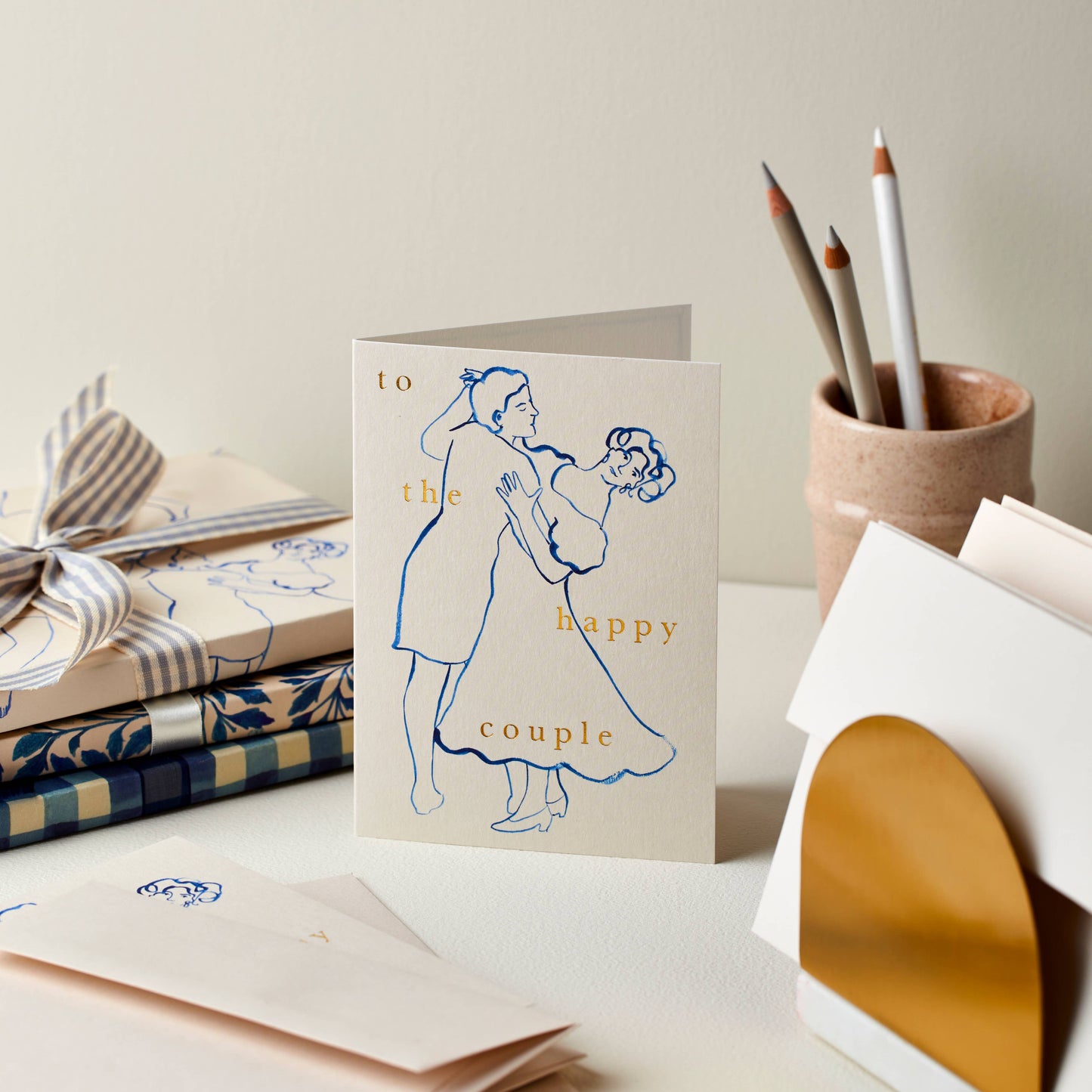 Light grey card with a painted blue illustration of two figures dancing, reading To the Happy Couple
