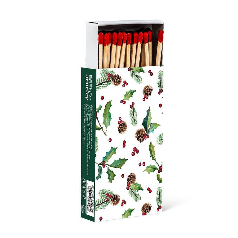 Long wooden matches in a green box illustrated with holly, pinecones, and berries, red-tipped matchsticks