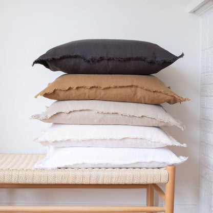 White fringed linen lumbar pillow cover styled on a bed