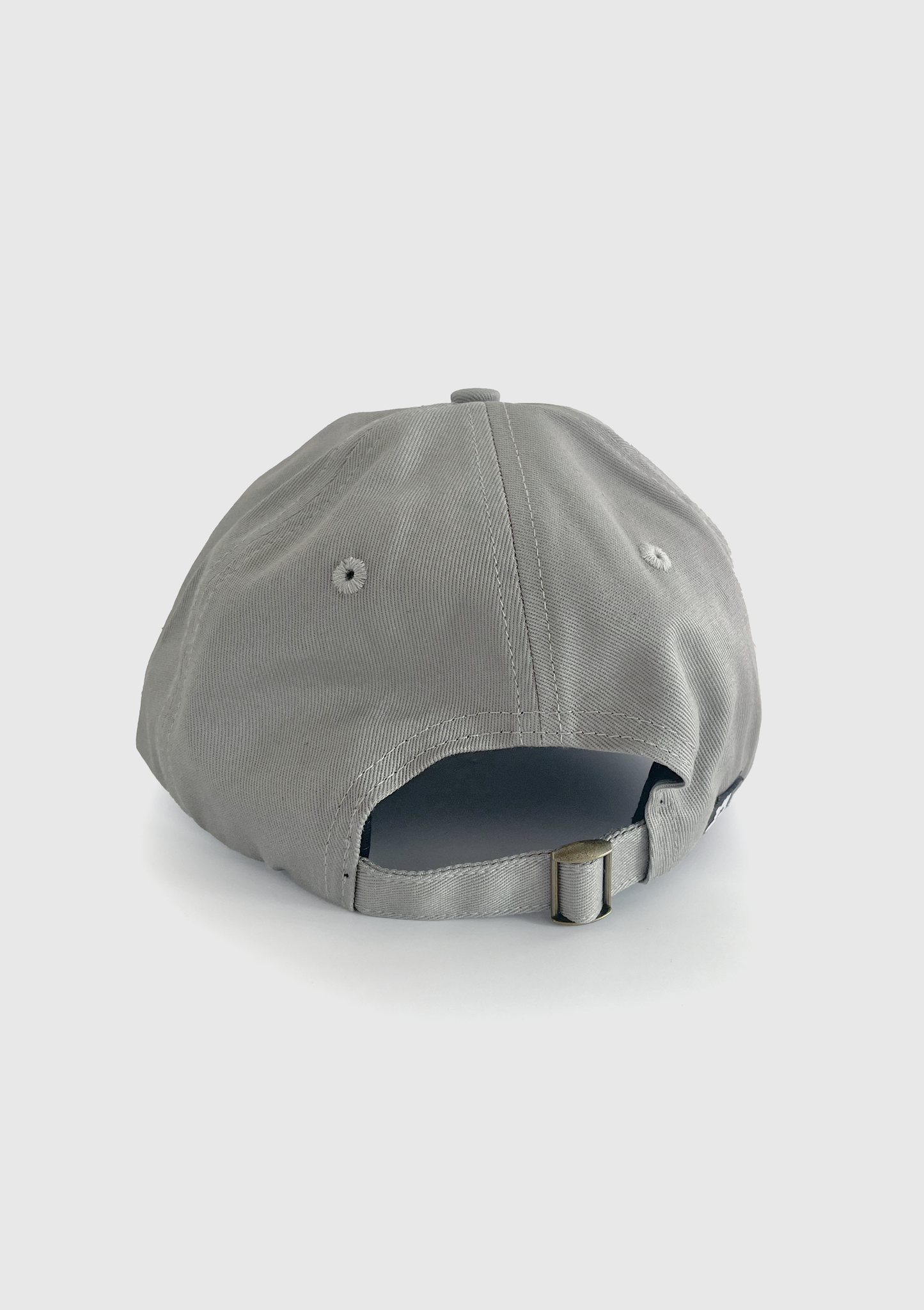 Close-up of embroidered triple-eyed critter design on grey dad hat - PABOOM