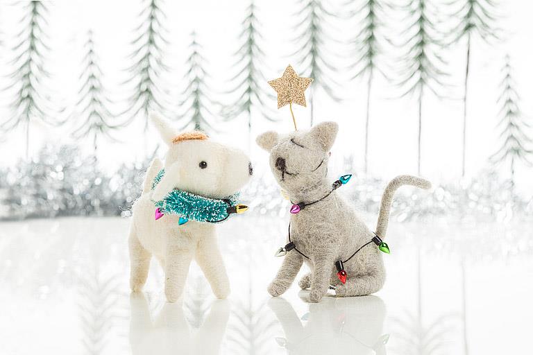 Close-up of the felted cat ornament's face and string light detail.