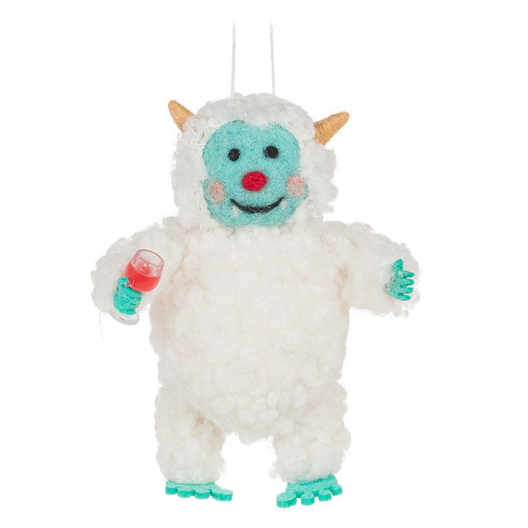 White wool felt yeti ornament with a turquoise face and feet, holding a small wine glass filled with red wine, smiling with rosy cheeks.