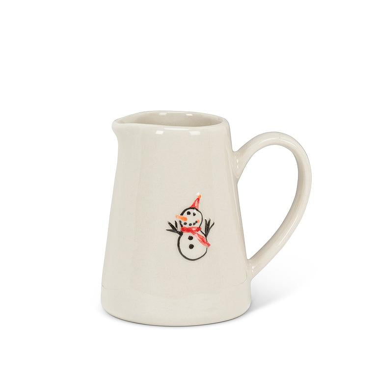 Small cream stoneware jug with a curved handle, hand-illustrated with a snowman wearing a red hat and scarf on the front.
