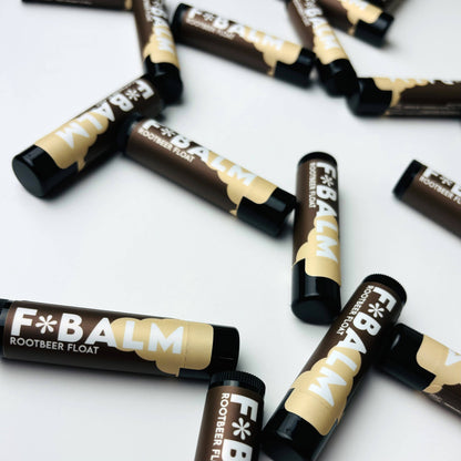 Scattered Charleston & Harlow F*Balm Rootbeer Float lip balm tubes with dark brown and cream label