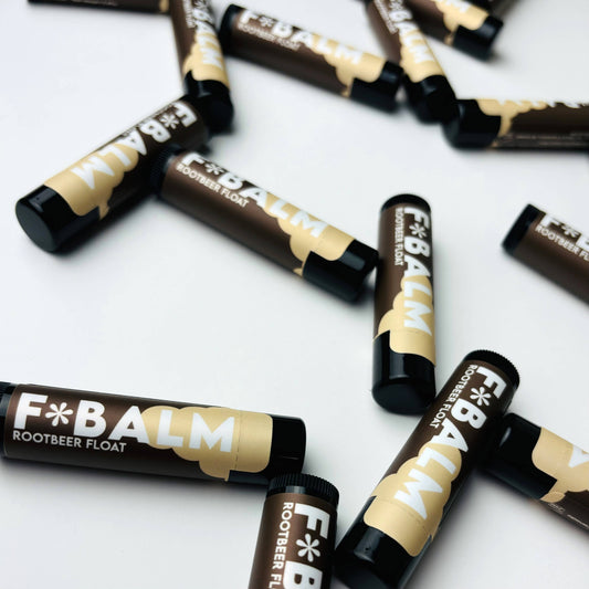 Scattered Charleston & Harlow F*Balm Rootbeer Float lip balm tubes with dark brown and cream label