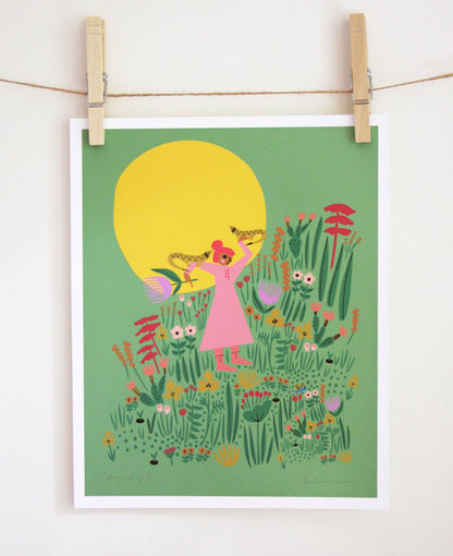 Art print of a woman in a pink dress holding up a lizard beneath a large yellow sun, surrounded by wildflowers on a green background, clipped to a string — PABOOM
