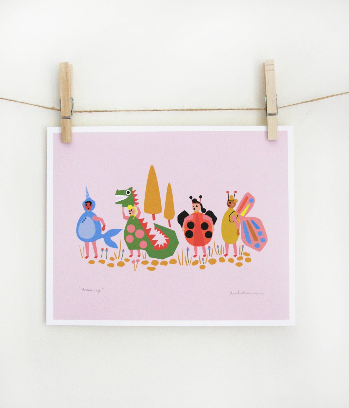 Art print of costumed characters including a mermaid, dragon, ladybug, and butterfly standing in a row on a lavender-pink background, clipped to a string — PABOOM
