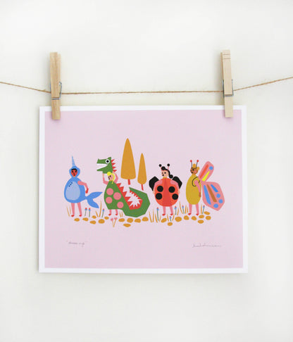 Art print of costumed characters including a mermaid, dragon, ladybug, and butterfly standing in a row on a lavender-pink background, clipped to a string — PABOOM