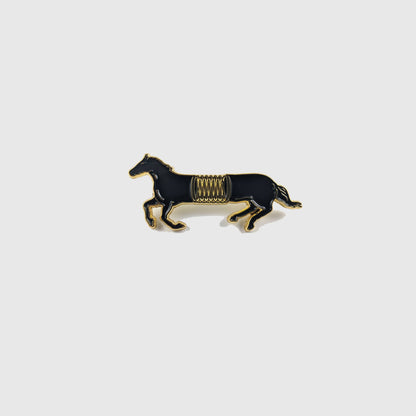Black and gold enamel pin of a horse mid-gallop with a spring coiled around its middle - PABOOM