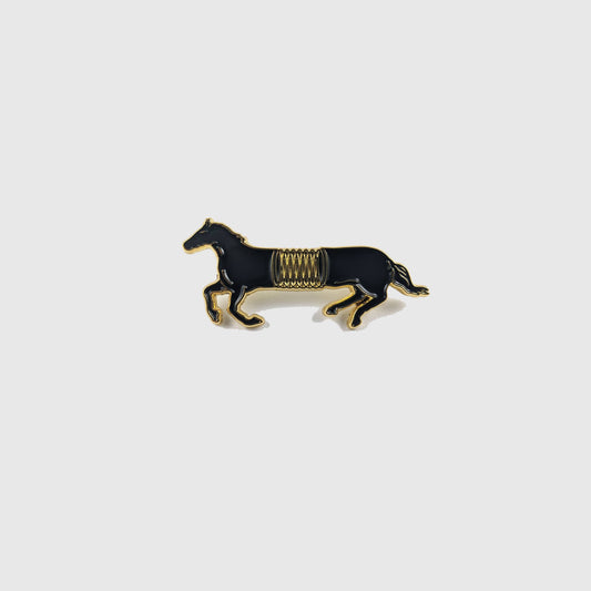 Black and gold enamel pin of a horse mid-gallop with a spring coiled around its middle - PABOOM