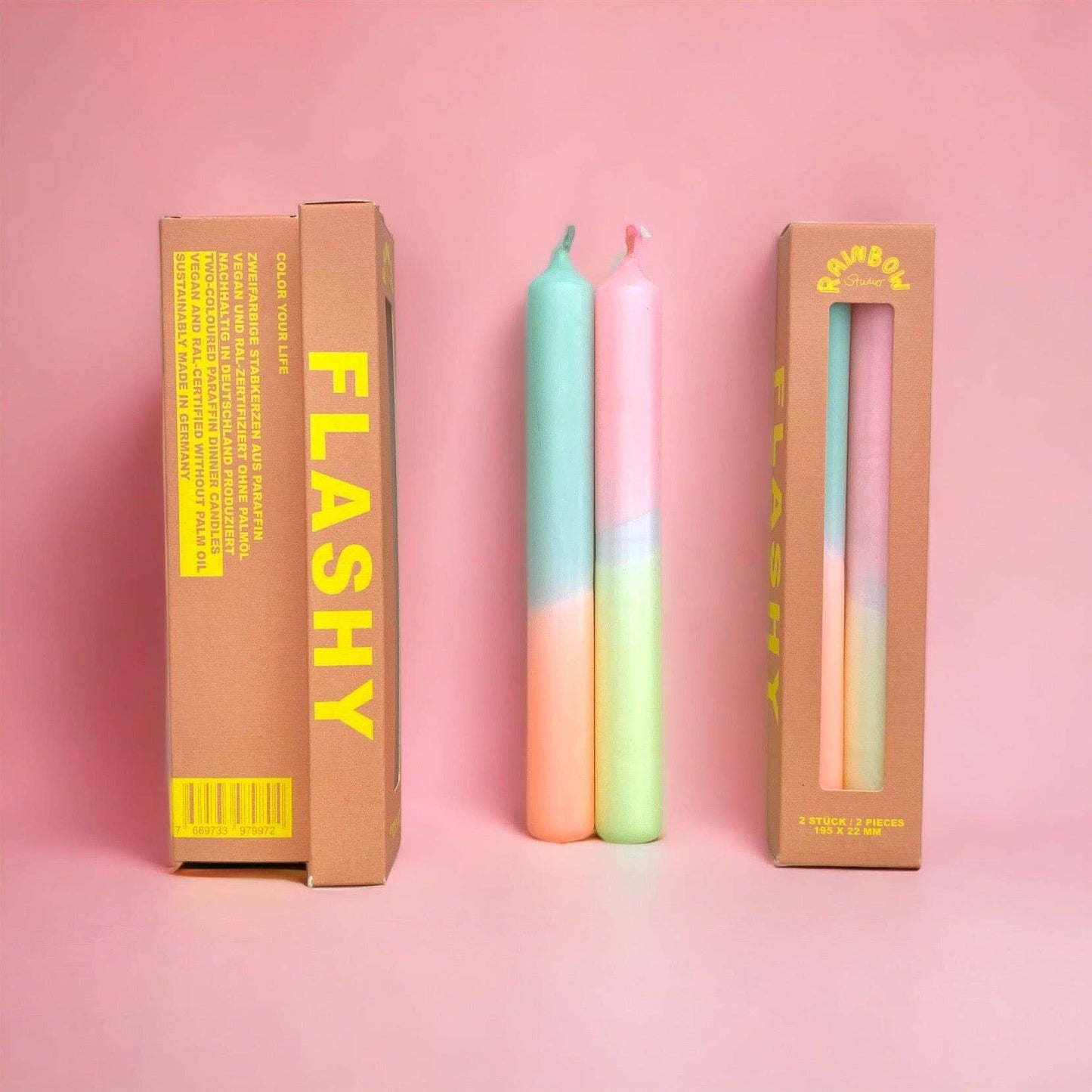Rainbow Studio Dinner Candle Set Flashy — two dip-dyed pastel taper candles in mint-peach and pink-mint gradients, shown beside kraft packaging